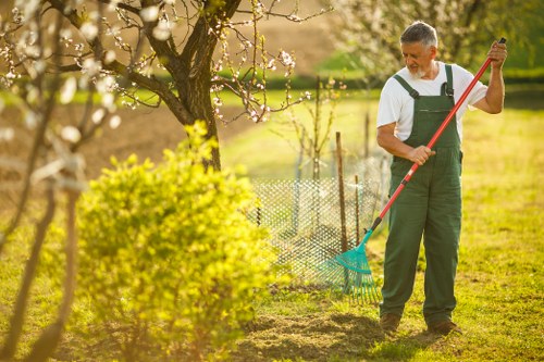 Garden clearance team removing overgrown shrubs in a residential rear yard
